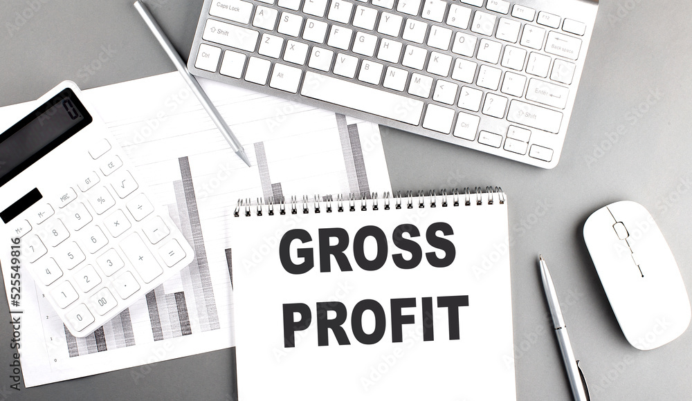 Aufkleber gross profit text written on notebook on grey background with chart and keyboard, business concept
