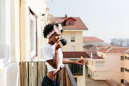 Black Woman Having Breakfast On Balcony