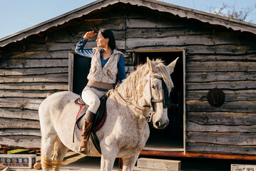 Woman ridding on white horse in nature