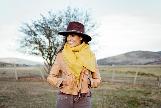 Stylish woman in scarf and cowboy hat