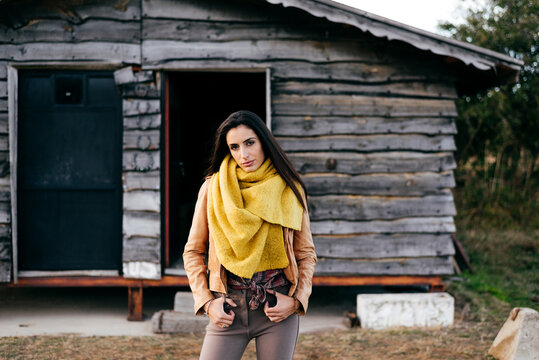 Stylish woman on ranch standing in a wooden cabin