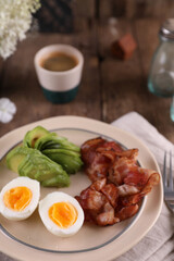 Breakfast with bacon, eggs and coffee on a wooden table