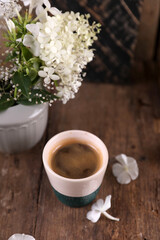 Small portion of coffee in a ceramic glass on a wooden table