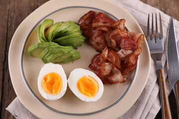 Breakfast with bacon, eggs and coffee on a wooden table