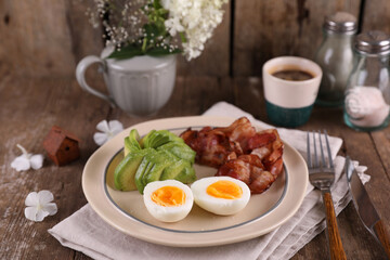 Breakfast with bacon, eggs and coffee on a wooden table