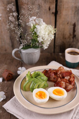 Breakfast with bacon, eggs and coffee on a wooden table