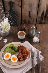 Breakfast with bacon, eggs and coffee on a wooden table