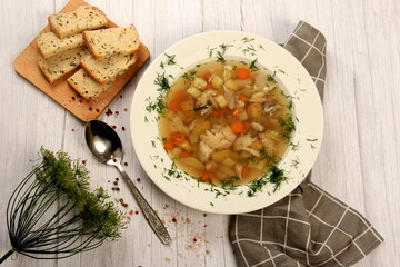 Fresh fish soup with vegetables in bowl on a white board background. Home kitchen recipes