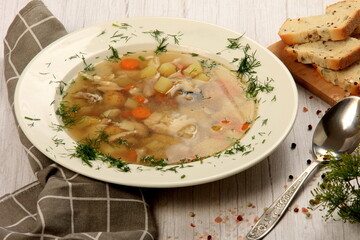 Fresh fish soup with vegetables in bowl on a white board background. Home kitchen recipes