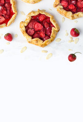 Top view of the mini biscuits with strawberries. Small pies on a white background. Space for text
