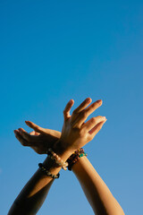 Hands with bracelets in mudra pose.