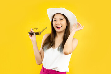 portrait of young asian woman smiling in trendy summer clothes posing isolated on yellow wall in studio.  travel airlines concept