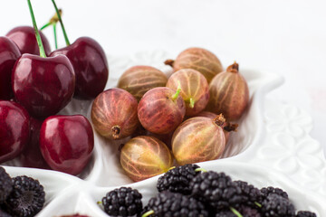Close-up of gooseberries on a fruit plate on a white background. Ripe berries. Vitamins and a healthy lifestyle