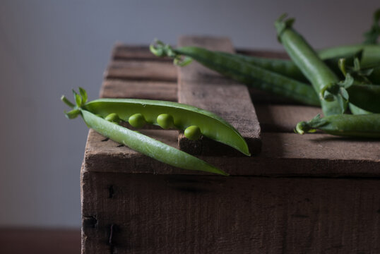 Closeup of pea pod on wood