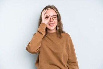 caucasian pretty woman smiling happily with funny face, joking and looking through peephole, spying...