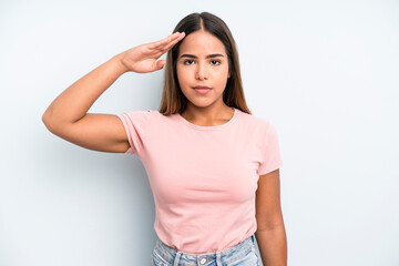 hispanic latin pretty woman greeting the camera with a military salute in an act of honor and...