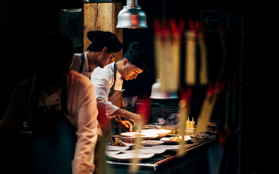 Coworking cooks serving food on counter