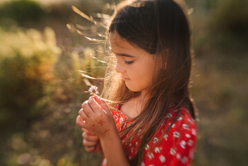 Cute girl in red dress dreaming in sunlight
