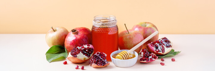 Web banner with apples, jar of honey and pomegranates on tray for Jewish holiday Rosh Hashanah