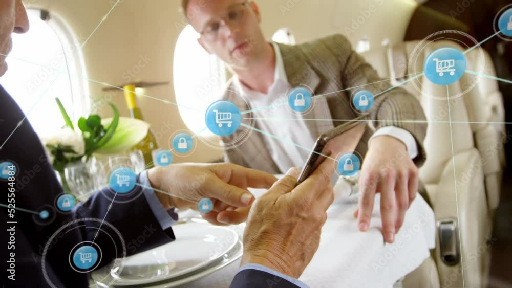 Poster animation of network of digital icons over two caucasian businessmen using digital tablet in a plane