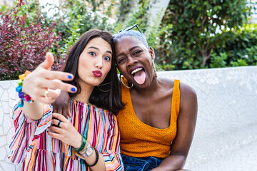 Positive couple of multiethnic lesbian women making faces at camera