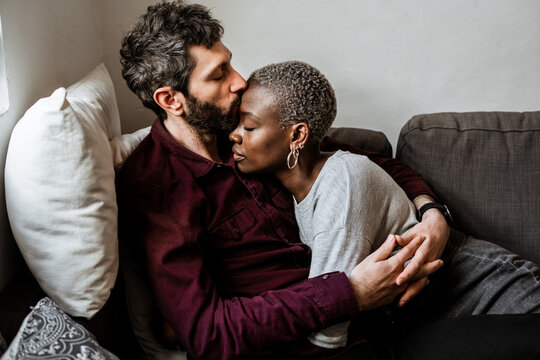 Young multiethnic couple resting on sofa
