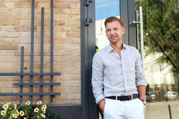 portrait of an attractive 30 year old man looking away near the restaurant in summer