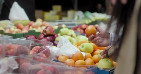 CU Female couple picking fruit in farmers market