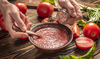 The process of cooking a traditional Italian sauce of tomatoes and basil from natural ripe...