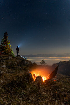 Man looking into valley in the fog with a fire burning in Vaud, Switzerland 2