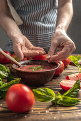 The process of cooking a traditional Italian sauce of tomatoes and basil from natural ripe vegetables. Rustic style