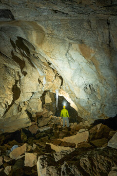 Man looking at ice stalactites in ice cave in Alpstein, Switzerland