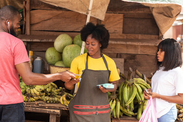 people in a local african market buying food items