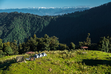 Fototapeta na wymiar A wide angle shot of Camping in the hills of Himalayan region of Uttarakhand, India with visible Gomukh Glacier peaks in the background.