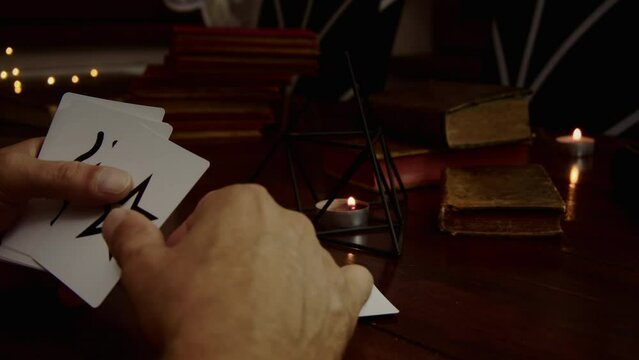 A man hands out ESP cards. A pyramid and old books are visible, several candles are lit,