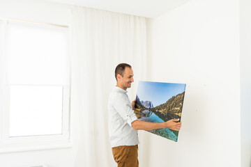 a man is holding a photo canvas