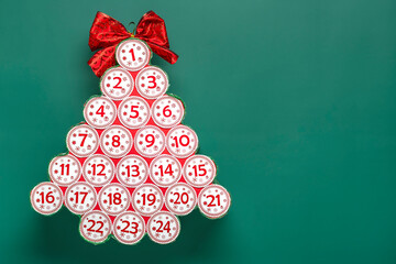 Advent calendar in shape of Christmas tree with numbers and ribbon instead of star, bokeh light on...