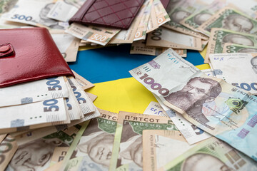 purse wallet with hryvnia on the background Ukrainian flag