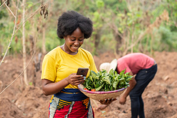 female african farmer making use of her phone