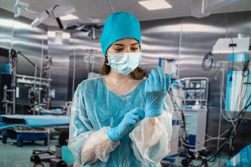 female doctor in operating room in a special uniform injecting medicine through the patient.