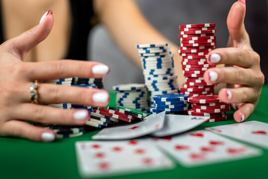 young woman is successfully gambling in a casino at table with cards chips and alcohol close-up