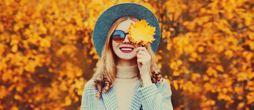 Autumn Portrait Of Beautiful Happy Smiling Woman With Yellow Maple Leaves Wearing Round Hat In The Park