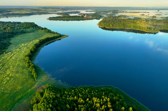 Lake on sunset, drone view. Rural landscape with lakes. Sunset over the forest lake. Drink water safe. Global drought crisis. Pond in countryside with fields and forest. Forest Lake at sunset. Nature. © MaxSafaniuk
