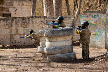 several children with machine guns and paintball masks play war