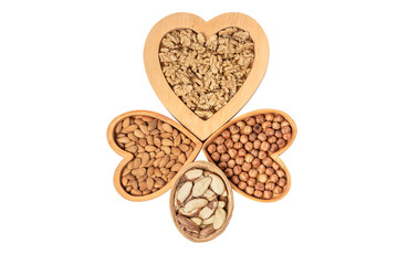 Variety of nuts in wooden cups in the shape of a heart isolated on a white background.