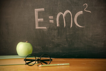 Equation E=mc2 handwritten on blackboard
