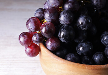 Fototapeta premium bunch of black grapes on a wooden plate 
