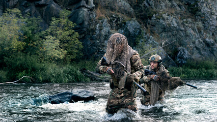 Two mercenary soldiers crossing the river after the completion of the sabotage operation. Soldiers covertly leave the combat area, fording across the river.