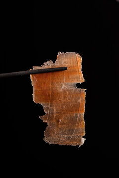 Delicious thin ham slice on black background