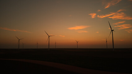 Fototapeta na wymiar Windmill farm park and turbines for producing green electricity.